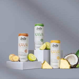 Leito Kava products with lemons, coconuts, and pineapple on a gray background