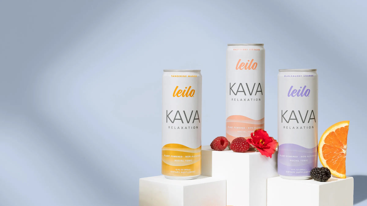 Leilo kava relaxation cans in Tangerine Mango, Raspberry Hibiscus and Blackberry Orange on white blocks with fresh fruit